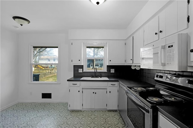 kitchen with stainless steel range with electric stovetop, sink, plenty of natural light, and white cabinets