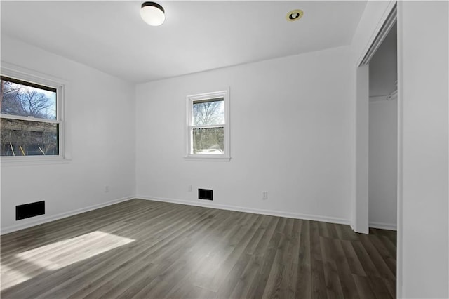 unfurnished bedroom with dark hardwood / wood-style flooring and a closet