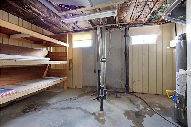 basement with a healthy amount of sunlight and water heater