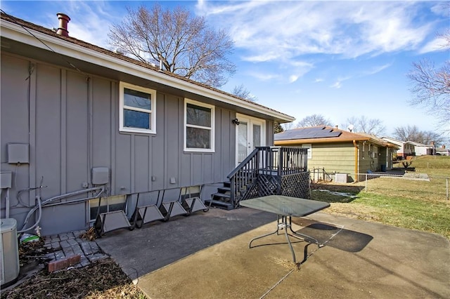 property entrance featuring a patio area and a lawn