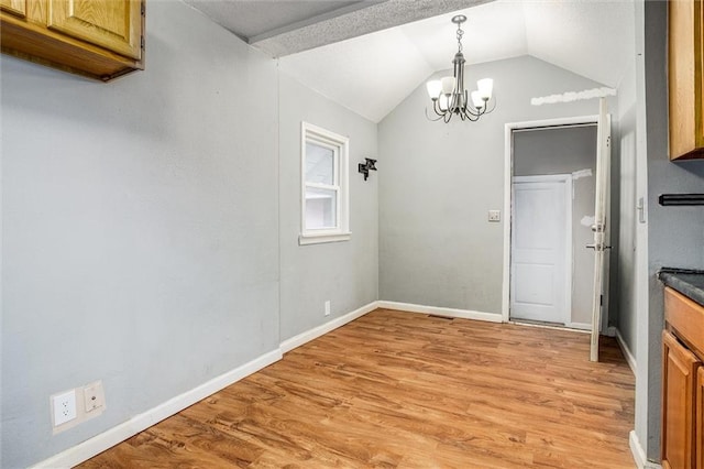 unfurnished dining area with vaulted ceiling, a chandelier, and light wood-type flooring