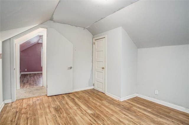 bonus room featuring vaulted ceiling and light hardwood / wood-style flooring