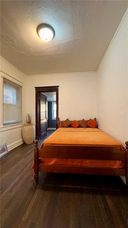 bedroom featuring a textured ceiling and wood finished floors