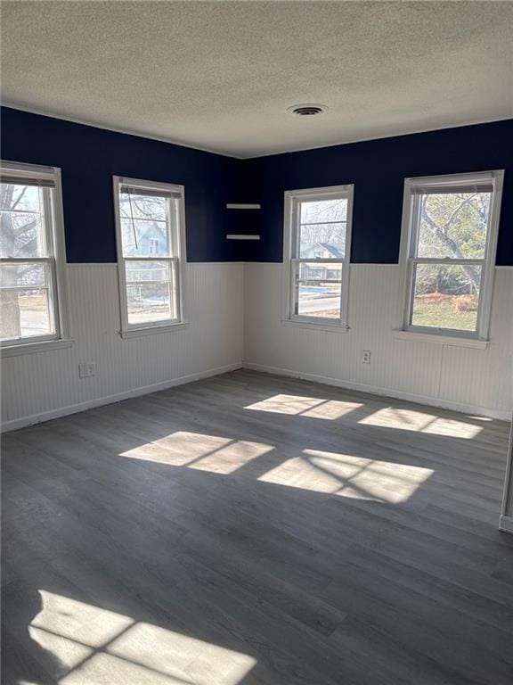 spare room featuring dark hardwood / wood-style flooring and a textured ceiling