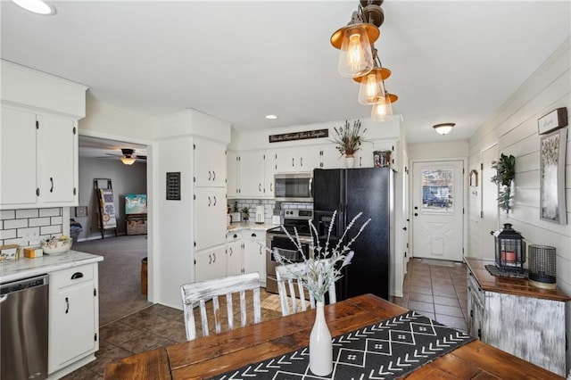 kitchen featuring appliances with stainless steel finishes, dark tile patterned flooring, and white cabinets