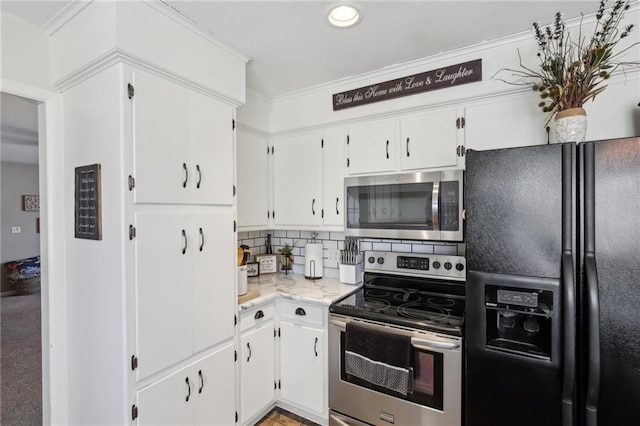 kitchen featuring tasteful backsplash, stainless steel appliances, crown molding, and white cabinets