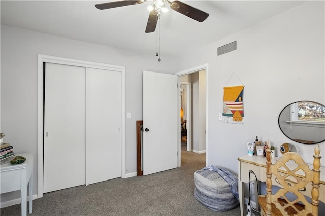 interior space featuring a closet, ceiling fan, and dark colored carpet