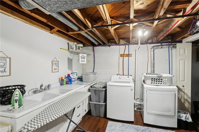 washroom featuring dark hardwood / wood-style flooring, sink, and washing machine and dryer