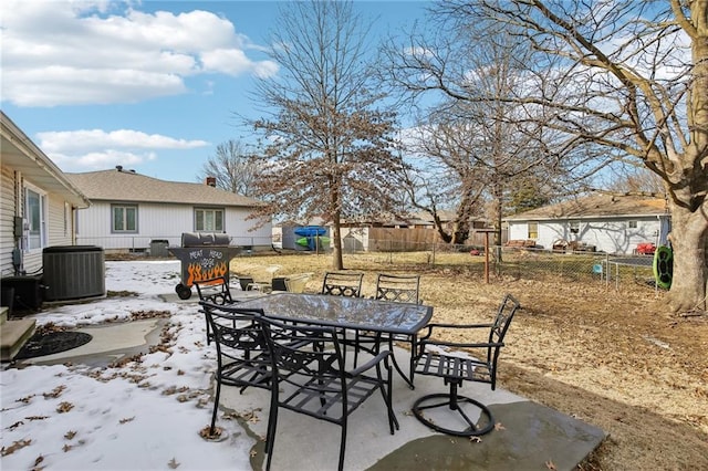 snow covered patio with a grill and central air condition unit