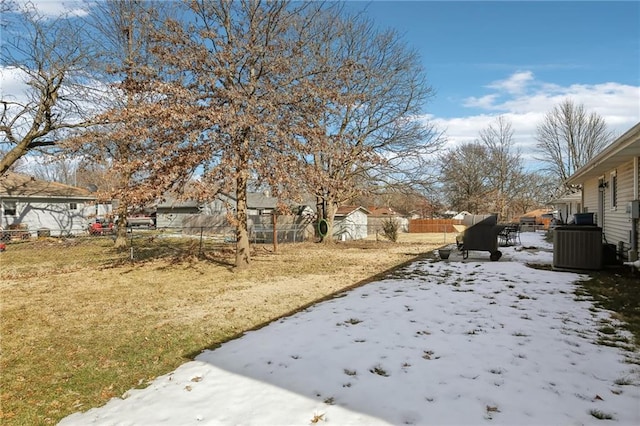 yard layered in snow featuring central air condition unit