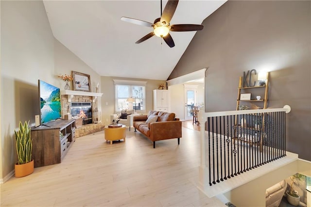 living room featuring ceiling fan, a fireplace, high vaulted ceiling, and light hardwood / wood-style flooring