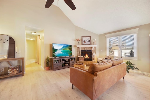 living room featuring ceiling fan, a fireplace, high vaulted ceiling, and light hardwood / wood-style flooring