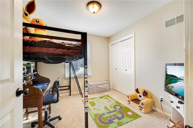 carpeted bedroom with a closet and a textured ceiling