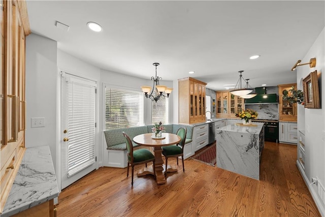 dining space featuring a chandelier, sink, and light wood-type flooring