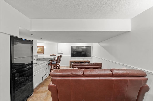 tiled living room featuring a textured ceiling