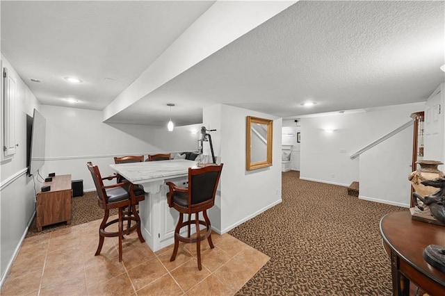 dining room with light colored carpet and a textured ceiling