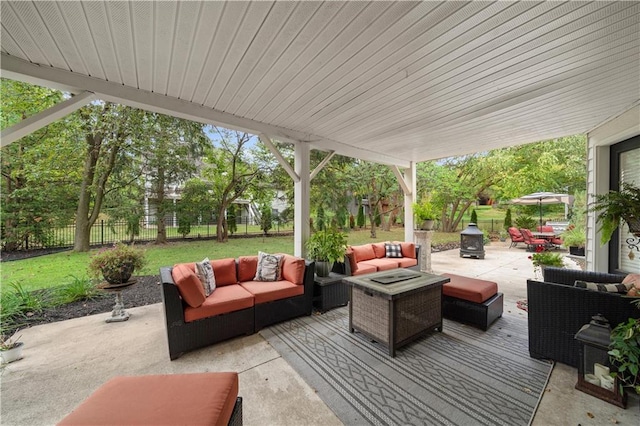 view of patio with an outdoor living space with a fire pit