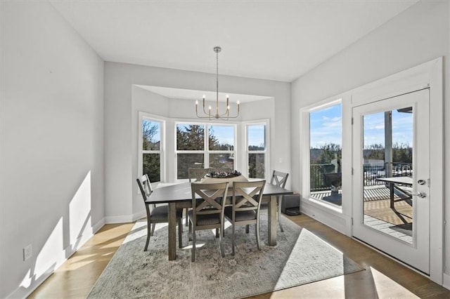 dining area with hardwood / wood-style flooring and a notable chandelier