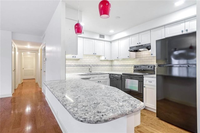 kitchen with sink, white cabinetry, light hardwood / wood-style flooring, kitchen peninsula, and black appliances