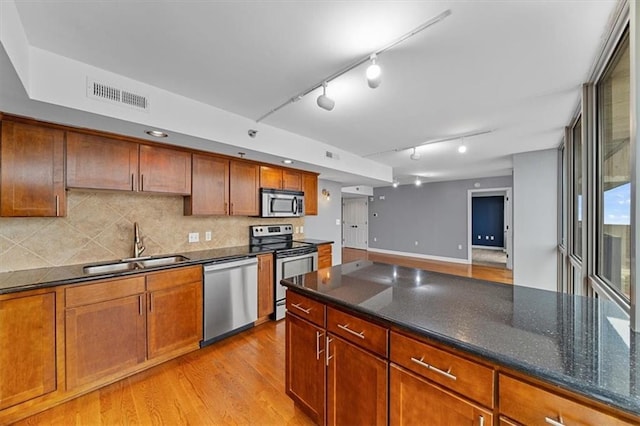 kitchen featuring light wood-type flooring, visible vents, a sink, tasteful backsplash, and appliances with stainless steel finishes