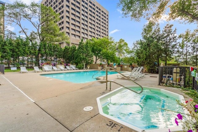 community pool featuring a patio and fence