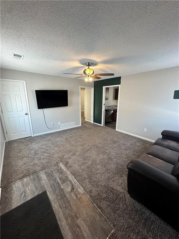 unfurnished living room with ceiling fan and a textured ceiling