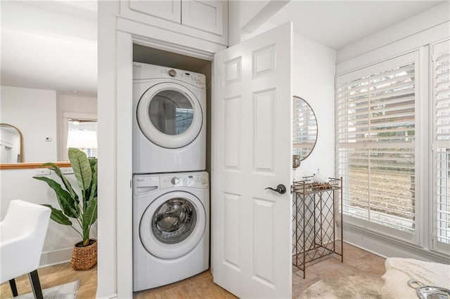 clothes washing area featuring stacked washer and clothes dryer