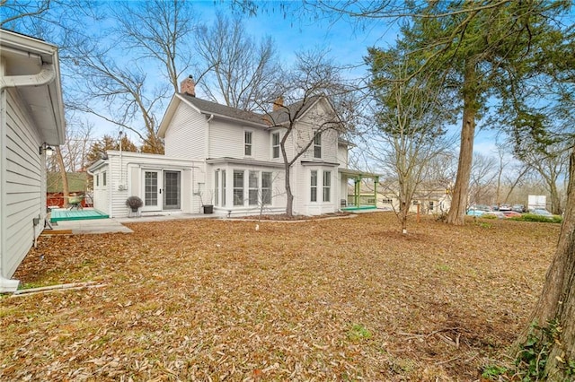 rear view of property with a swimming pool and a patio