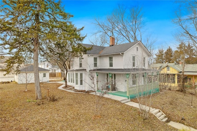 rear view of house featuring a yard