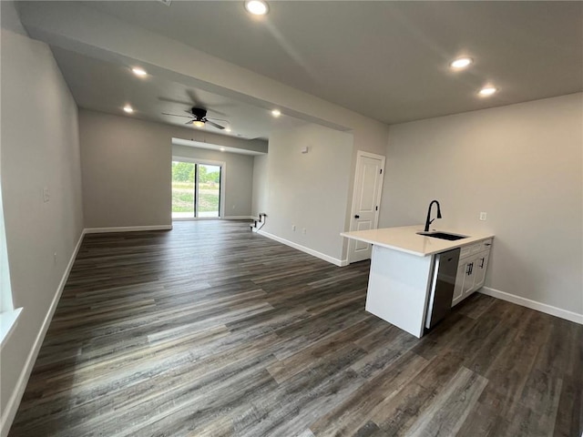 interior space featuring dark wood-type flooring, stainless steel dishwasher, ceiling fan, and sink