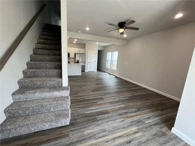 stairway featuring wood-type flooring and ceiling fan