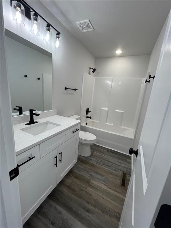 full bathroom featuring wood-type flooring, toilet, shower / bathing tub combination, and vanity