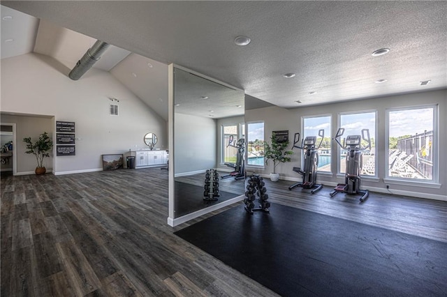 workout area with dark hardwood / wood-style flooring, vaulted ceiling, and a textured ceiling