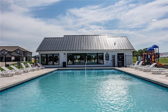 view of pool with a patio and a playground