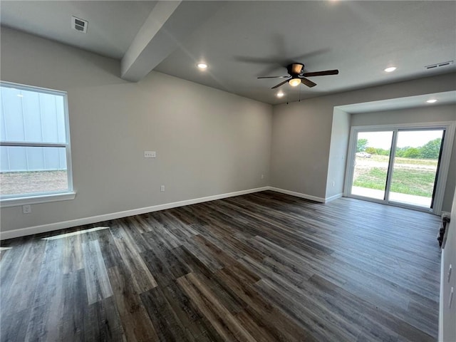 unfurnished room featuring baseboards, visible vents, dark wood finished floors, and a ceiling fan