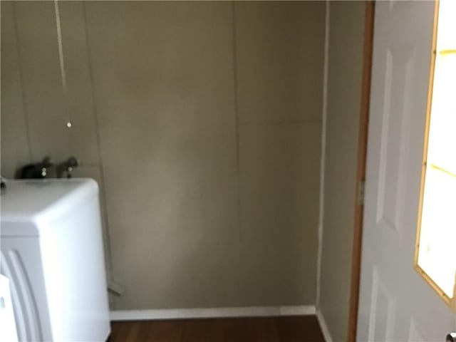 washroom featuring dark wood-type flooring and washer / dryer