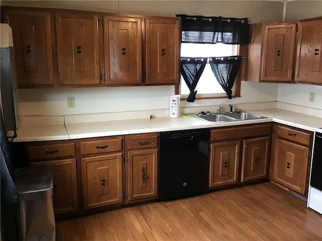 kitchen with dishwasher, sink, and light wood-type flooring