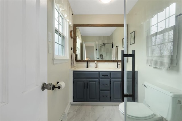 bathroom with vanity, toilet, and a shower with shower door