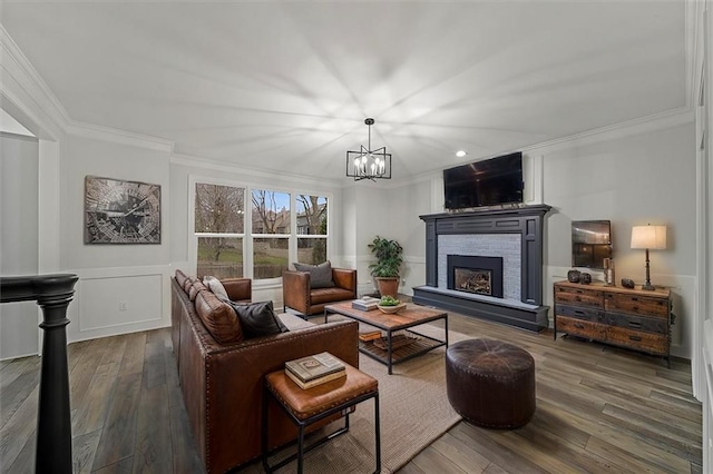 living room with ornamental molding, dark hardwood / wood-style flooring, and a chandelier