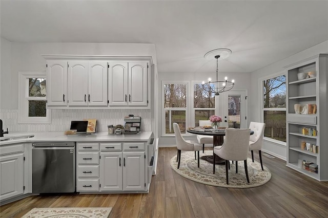 kitchen featuring white cabinetry, hanging light fixtures, dishwasher, a notable chandelier, and hardwood / wood-style floors