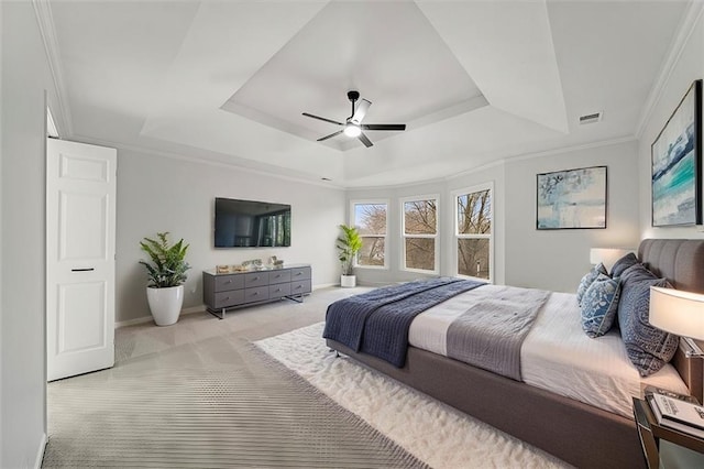 carpeted bedroom featuring crown molding, ceiling fan, and a tray ceiling