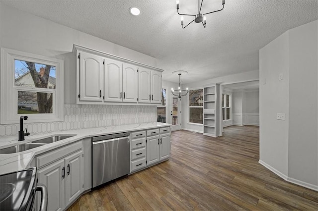 kitchen with sink, white cabinetry, stainless steel appliances, decorative light fixtures, and a chandelier