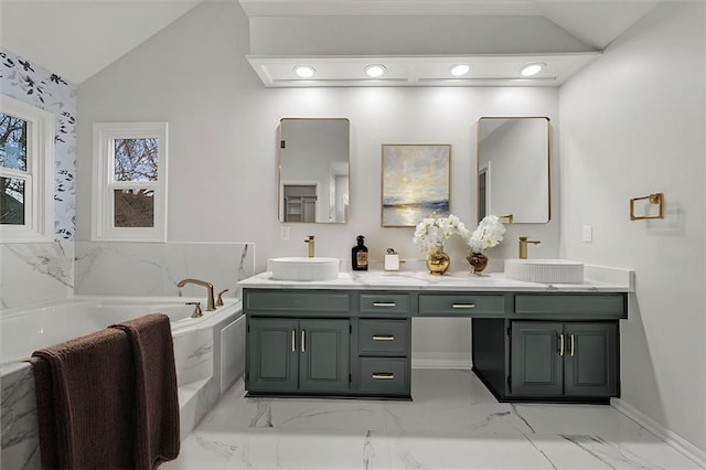 bathroom featuring vaulted ceiling, vanity, and a bathtub