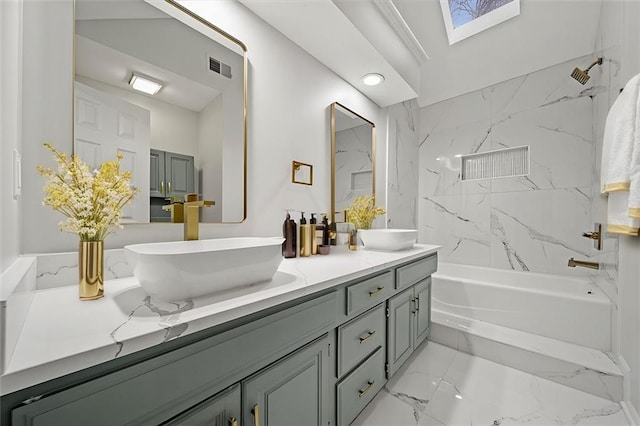 bathroom featuring tiled shower / bath combo, vanity, and a skylight