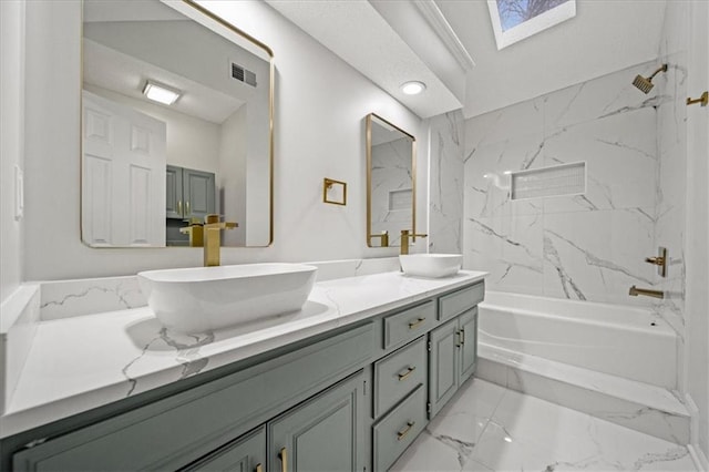 bathroom featuring tiled shower / bath, vanity, and a skylight