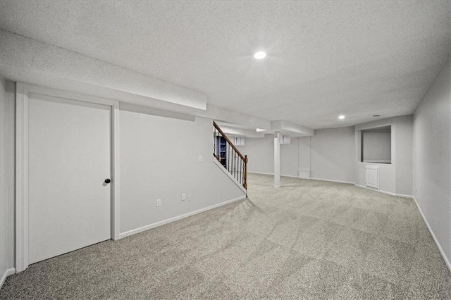 basement featuring carpet flooring and a textured ceiling