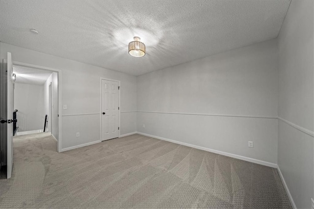 carpeted spare room with a textured ceiling