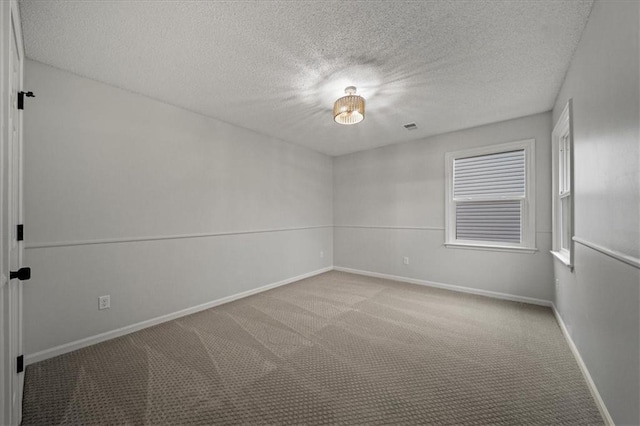 carpeted spare room with a textured ceiling