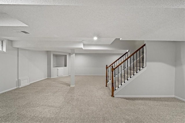 basement featuring carpet floors and a textured ceiling