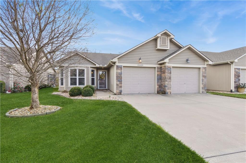 single story home featuring a garage and a front lawn